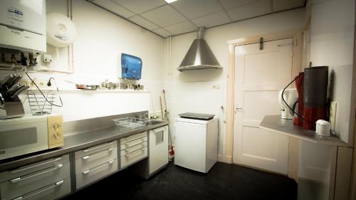 a white kitchen with a sink and a refrigerator at Rumah Senang in Den Helder