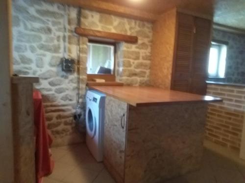 una cucina con lavatrice e asciugatrice in una stanza di Maison vue mer et campagne a Sibiril