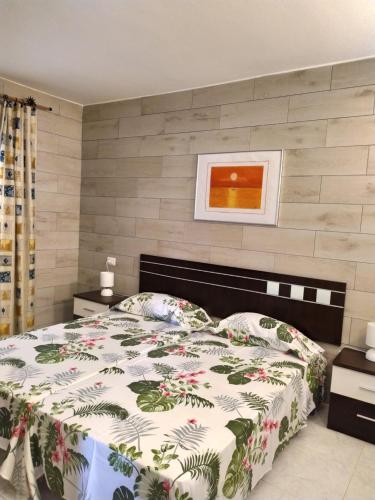 1 dormitorio con 1 cama con edredón de flores en Apartamento Garcey en Ajuy