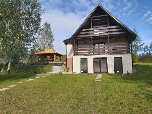 una casa con un gran patio y un cenador en Leśna Chata Kaszuby, en Sulęczyno