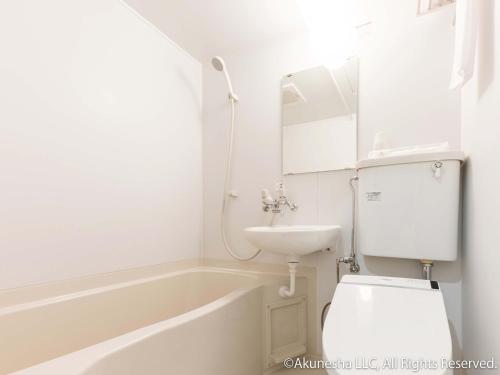 a bathroom with a toilet and a sink and a tub at Oyado Midokoi in Akune