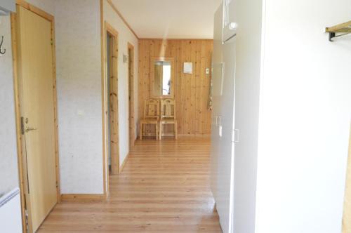 an empty hallway with wooden floors and white walls at Blåsjöns stugby in Stora Blåsjön