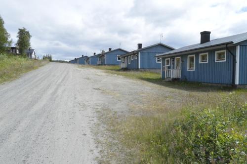 a dirt road next to a row of houses at Blåsjöns stugby in Stora Blåsjön