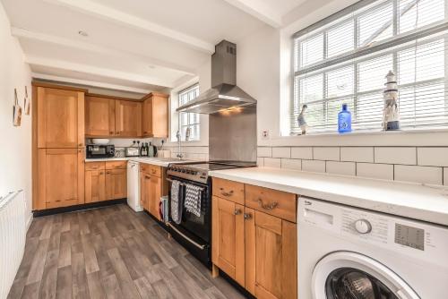 a kitchen with a washer and dryer in it at Lime Kiln Cottage, Pentewan, Cornwall in Pentewan