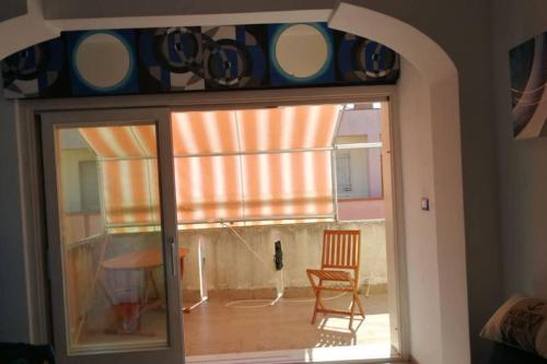 a room with a window with a chair and a table at Palmahouse in Alghero