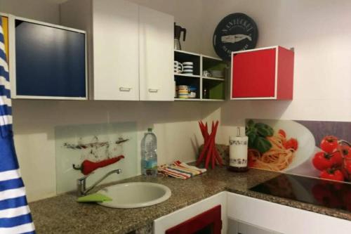 a kitchen counter with a sink and a clock on the wall at Palmahouse in Alghero