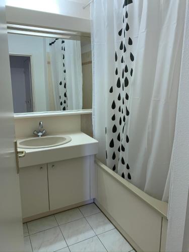 une salle de bain avec un lavabo et un rideau de douche dans l'établissement Mandana, au Cap d'Agde