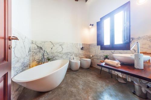 bagno con 2 lavandini, vasca e 2 servizi igienici di GuestHost - Vakalu Piazza Duomo Charming Apartment a Siracusa