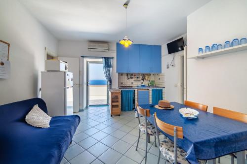een keuken en eetkamer met een blauwe tafel en stoelen bij La casa del capitano ponza in Ponza
