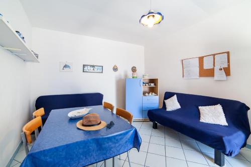 een kamer met een tafel en een bed en een blauwe bank bij La casa del capitano ponza in Ponza