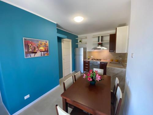 una cucina con tavolo e parete blu di Appartamento Sole e Mare a Stintino