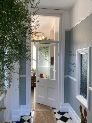 a hallway with a white door and a window at The Devonian in Ilfracombe