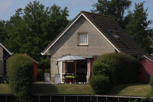 a house with a table and an umbrella at Haus am Vliet in Medemblik