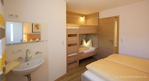 une salle de bain avec un lavabo et une chambre avec un lit dans l'établissement Apartment Schneeberger, à Stummerberg