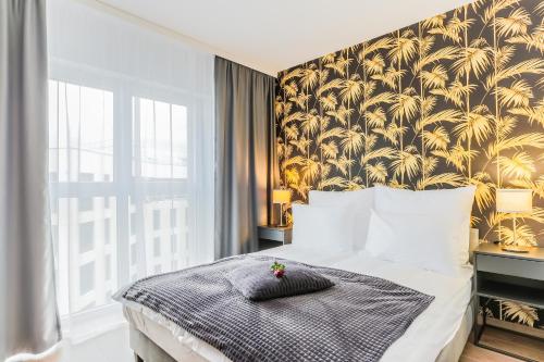 弗次瓦夫的住宿－COIN Apartamenty Krakowska，一间卧室配有一张带金色壁纸的大床