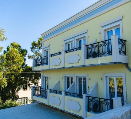 um edifício amarelo com varandas em cima em Hotel Santorini em Fira