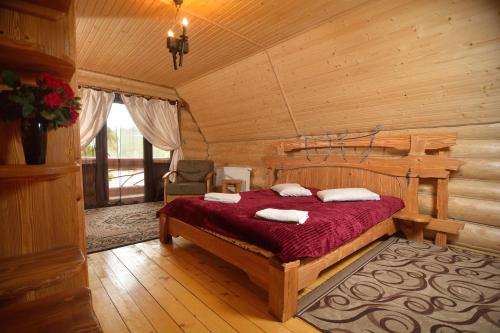 a bedroom with a bed in a log cabin at Drin-lux in Slavske