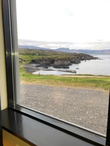 a window with a view of a body of water at Hellnar Ocean View Villa in Hellnar