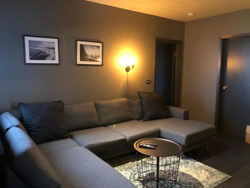 a living room with a couch and a table at Hellnar Ocean View Villa in Hellnar