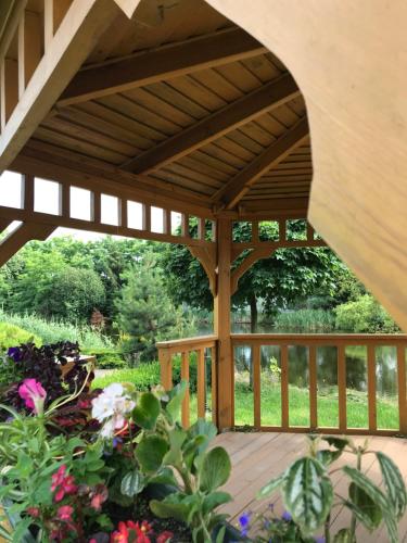 a wooden pergola in a garden with flowers at Фінський будинок для ідеального романтичного чи сімейного відпочинку in Makovishche