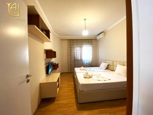 فندق فيلا إي آرتي سيتي سنتر  في تيرانا: غرفة نوم مع سرير مع اثنين من الحيوانات المحشوة عليه
