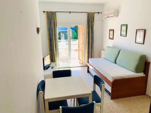 リョレート・デ・マルにあるEva Aparthotelのベッドとテーブルと椅子のある部屋