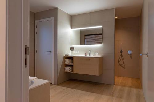 een badkamer met een wastafel en een spiegel bij B&B El Bayo in Ravels
