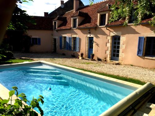 una gran piscina azul frente a una casa en Le Vieux Saule en Saints
