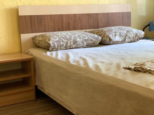 a bed with two pillows on top of it at Hotel Lev in Zatoka