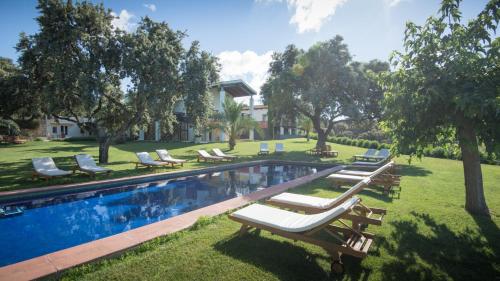 een zwembad met ligstoelen naast een huis bij The Lodge Ronda in Ronda