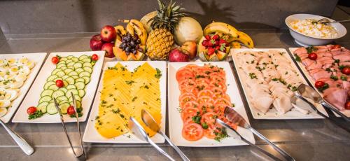 a bunch of different types of fruits and vegetables on plates at Garden Court OR Tambo International Airport in Kempton Park