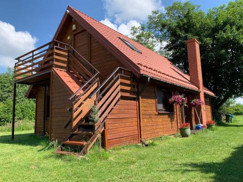eine kleine Holzhütte mit einer Treppe im Hof in der Unterkunft Domek Mikołajki in Mikołajki