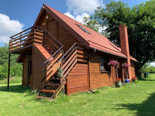 a small wooden cabin with a staircase in a yard at Domek Mikołajki in Mikołajki