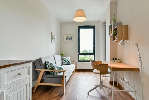 a living room with a couch and a desk at LTC Apartments Silva in Gdynia
