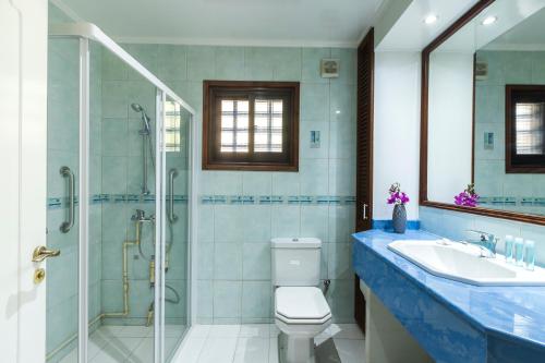 y baño con ducha, aseo y lavamanos. en Resitour - Kamares Village, en Pafos