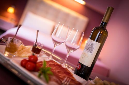 a bottle of wine next to a plate of food and wine glasses at Castello degli Angeli in Carobbio degli Angeli