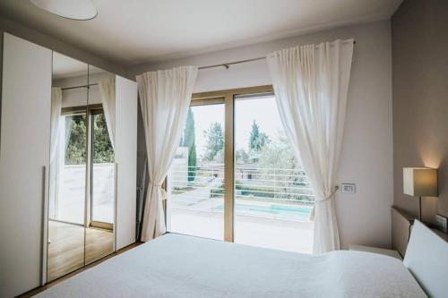 a bedroom with a bed and a large window at Casa Chiara in Gardone Riviera