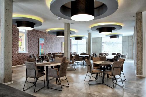 un restaurante con mesas y sillas y techos grandes en Hotel Apart GO25, en Herford