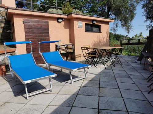 2 blaue Stühle und Tische auf einer Terrasse in der Unterkunft Villa Rocca Leivi in Leivi