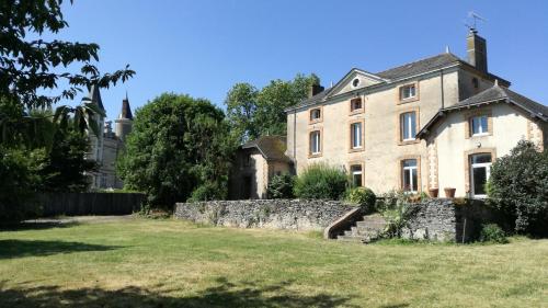 uma casa velha com uma parede de pedra no quintal em Les Gîtes du Chateau de la Morinière em Beaupréau