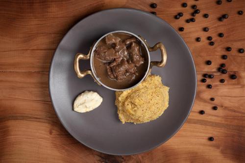 a plate with a bowl of chocolate pudding and some food at Rifugio Cereda in Fiera di Primiero