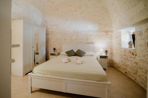 a bedroom with a large bed with two towels on it at Antica Tenuta dei Trulli in Alberobello
