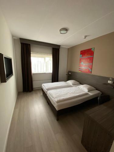 ein großes Schlafzimmer mit 2 Betten und einem TV in der Unterkunft Hotel de Keizerskroon Amsterdam-Schiphol-Halfweg in Halfweg