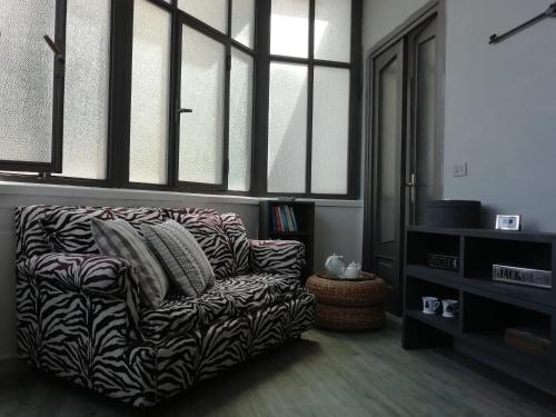 uma sala de estar com um sofá e algumas janelas em B&B Maria Rosaria Home em San Marzano sul Sarno