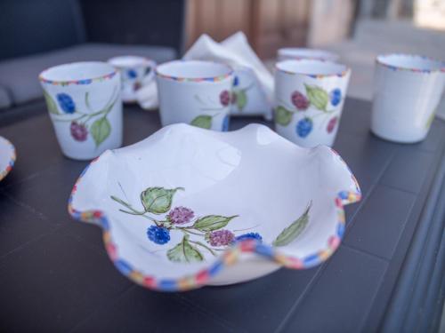 B&B Il Gelso Rooms في تيرمي فيلياتوري: مجموعة من الكؤوس ووعاء على طاولة