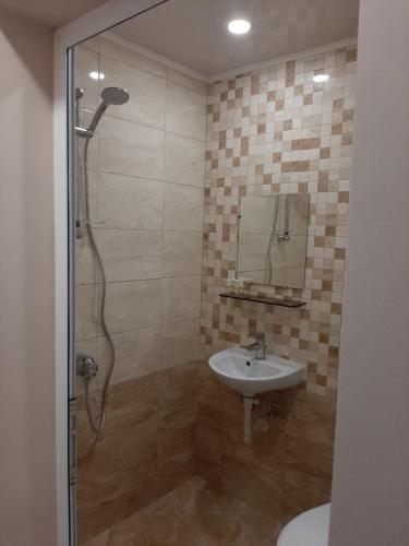a bathroom with a shower and a sink at Хотел Таганрог in Cherven Bryag