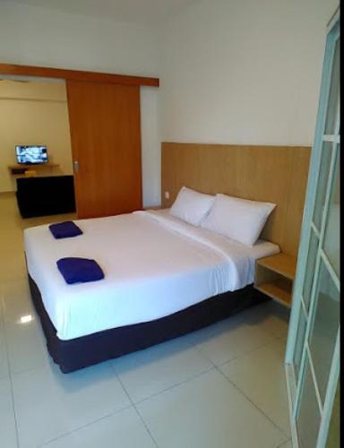 a bedroom with a large white bed in a room at Marina Height Seaview Resort, Teluk Batik, Lumut in Kampong Tebing Rabak