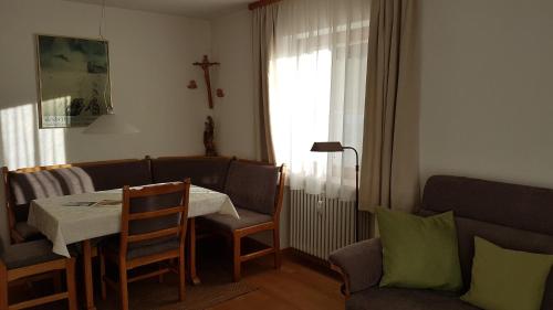a living room with a table and a couch at Ferienwohnung Halder, Ihr Bett im Allgäu in Bad Hindelang