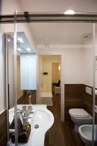 a bathroom with a sink and a toilet and a mirror at Freedom Love B&B in Rome