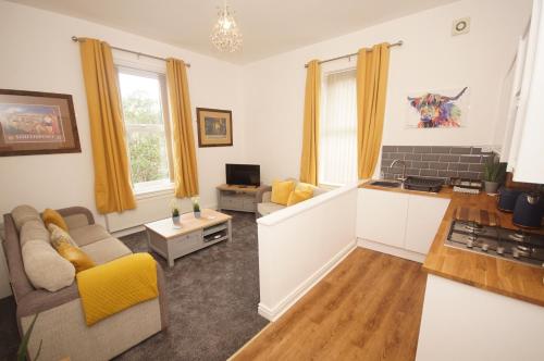 a living room with a couch and a table at Grosvenor Lodge Birkdale Southport in Southport